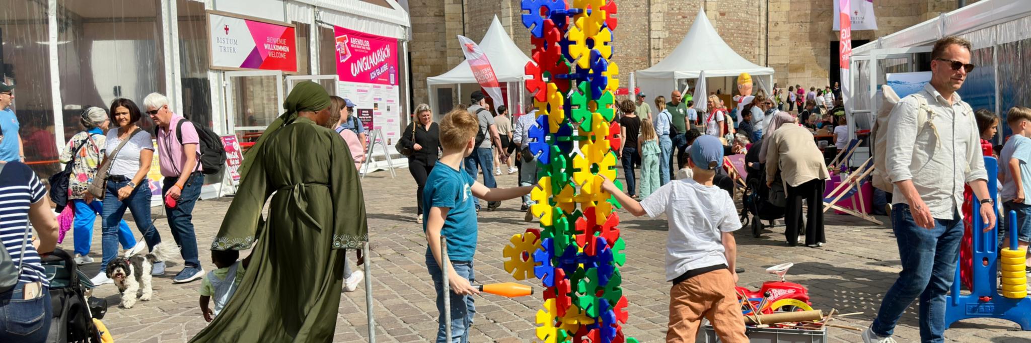 Menschen und Spielgeräte auf dem Platz vor dem Dom