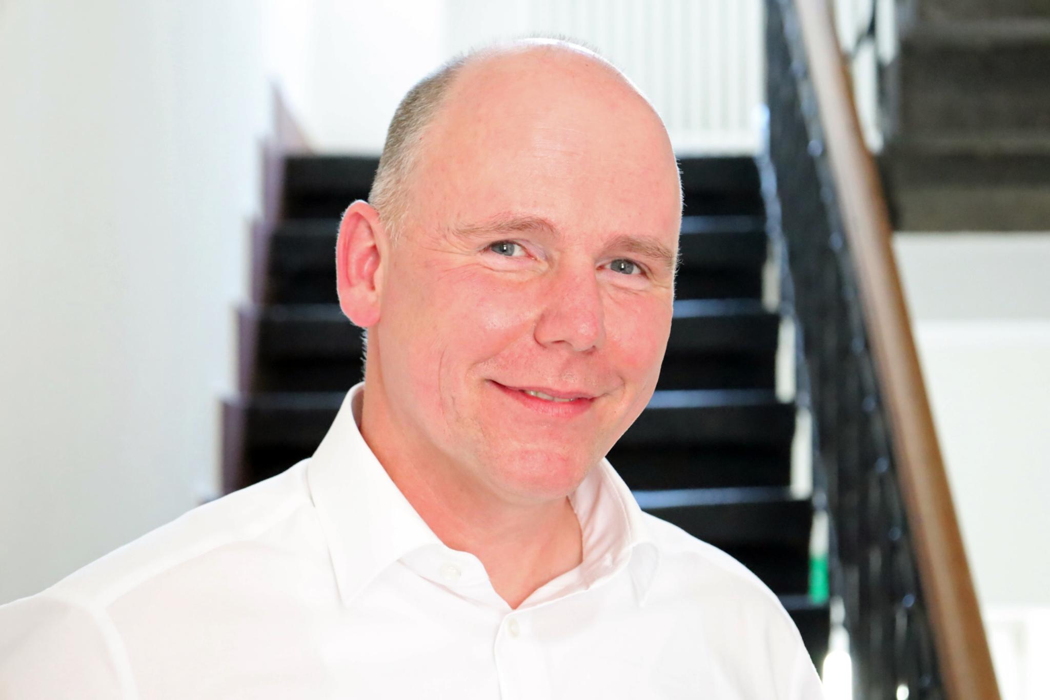Auf dem Foto zu sehen ist Torsten Wahl vor einer Treppe stehend